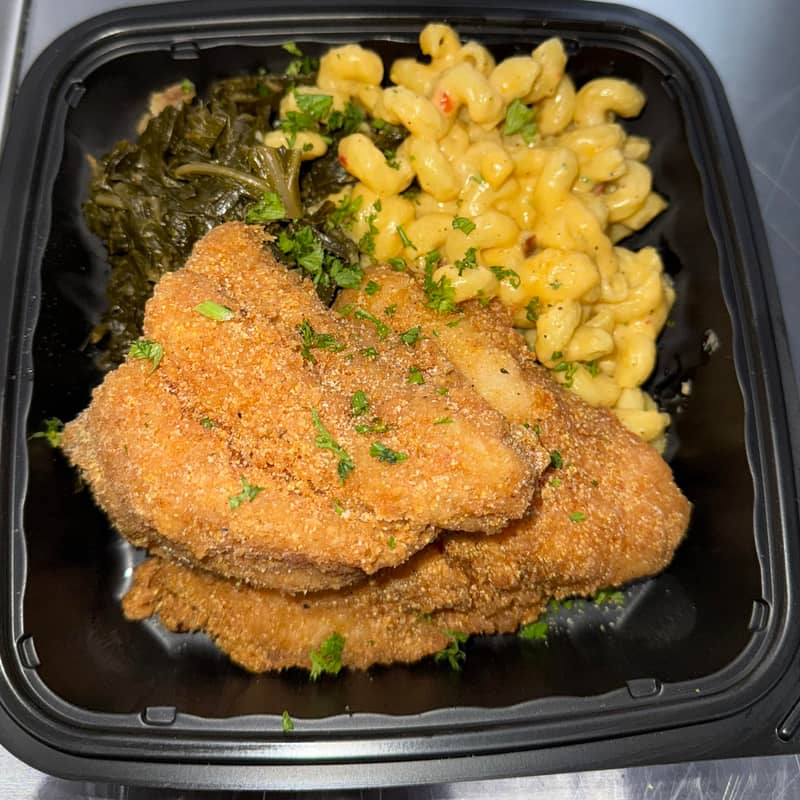 Three to four pieces of fried catfish with two Southern sides